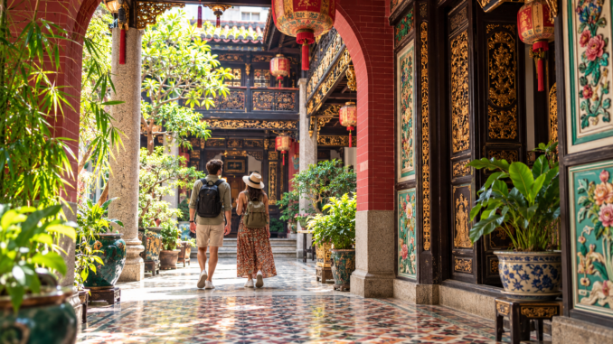 Pareja de viajeros en un patio histórico de George Town, Penang